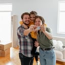 Una familia joven estadounidense emocionada muestra las llaves de su propia casa, una pareja feliz que compra la primera casa juntos, un esposo y una esposa sonrientes compran una nueva propiedad. Concepto de propiedad