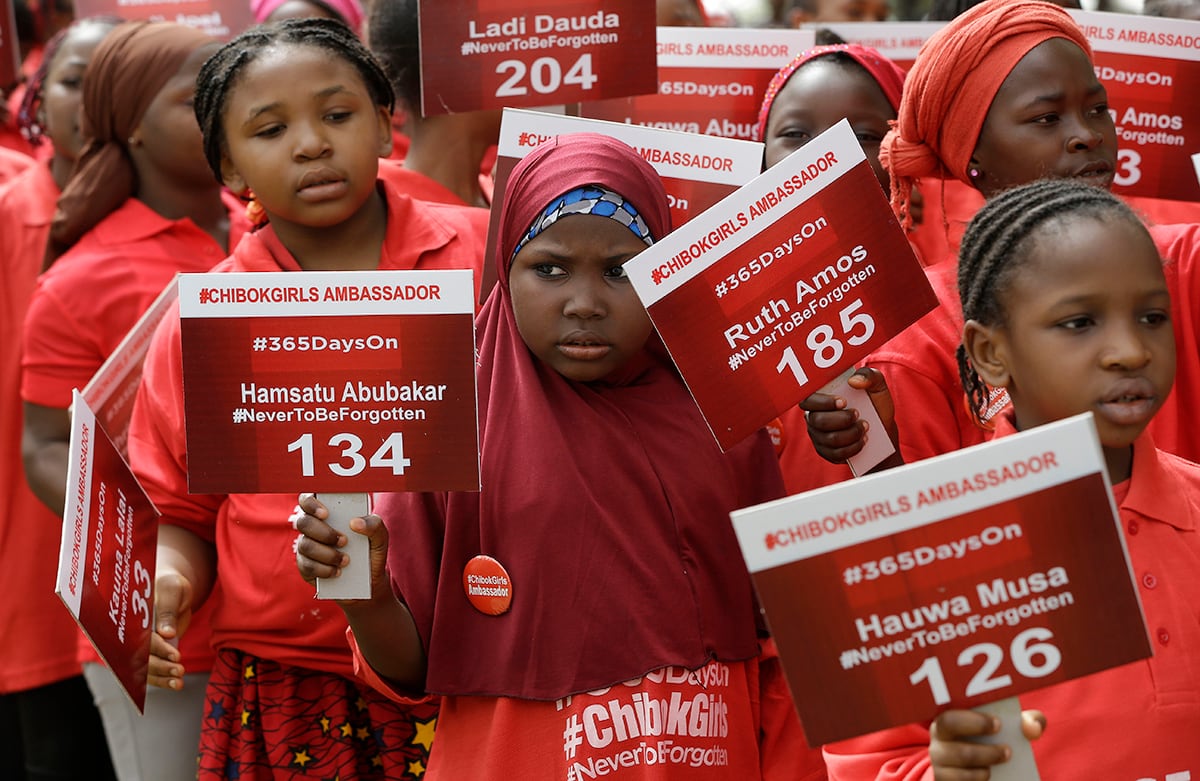 Pequeñas, conocidas como embajadoras de Chibok, cargan carteles con los nombres de las niñas de la escuela secundaria raptadas hace un año en Chibok, Nigeria. (AP)
