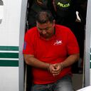 Jorge Luis Alfonso Lopez, center, deplanes at the police station in Bogota, Colombia, Thursday, Aug. 2, 2012. Alfonso Lopez is a former mayor of Magangue and the son of a controversial businesswoman known as "La Gata', now under house arrest for her ties to paramilitary groups. Alfonso, who is facing murder charges for two men; one a journalist, the other a student, was captured on a farm near Colombia's Caribbean coast, Thursday morning. (AP Photo/Fernando Vergara)