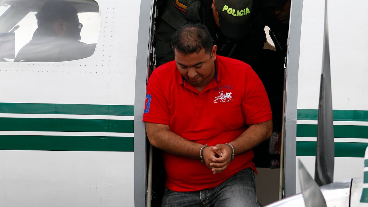Jorge Luis Alfonso Lopez, center, deplanes at the police station in Bogota, Colombia, Thursday, Aug. 2, 2012. Alfonso Lopez is a former mayor of Magangue and the son of a controversial businesswoman known as "La Gata', now under house arrest for her ties to paramilitary groups. Alfonso, who is facing murder charges for two men; one a journalist, the other a student, was captured on a farm near Colombia's Caribbean coast, Thursday morning. (AP Photo/Fernando Vergara)