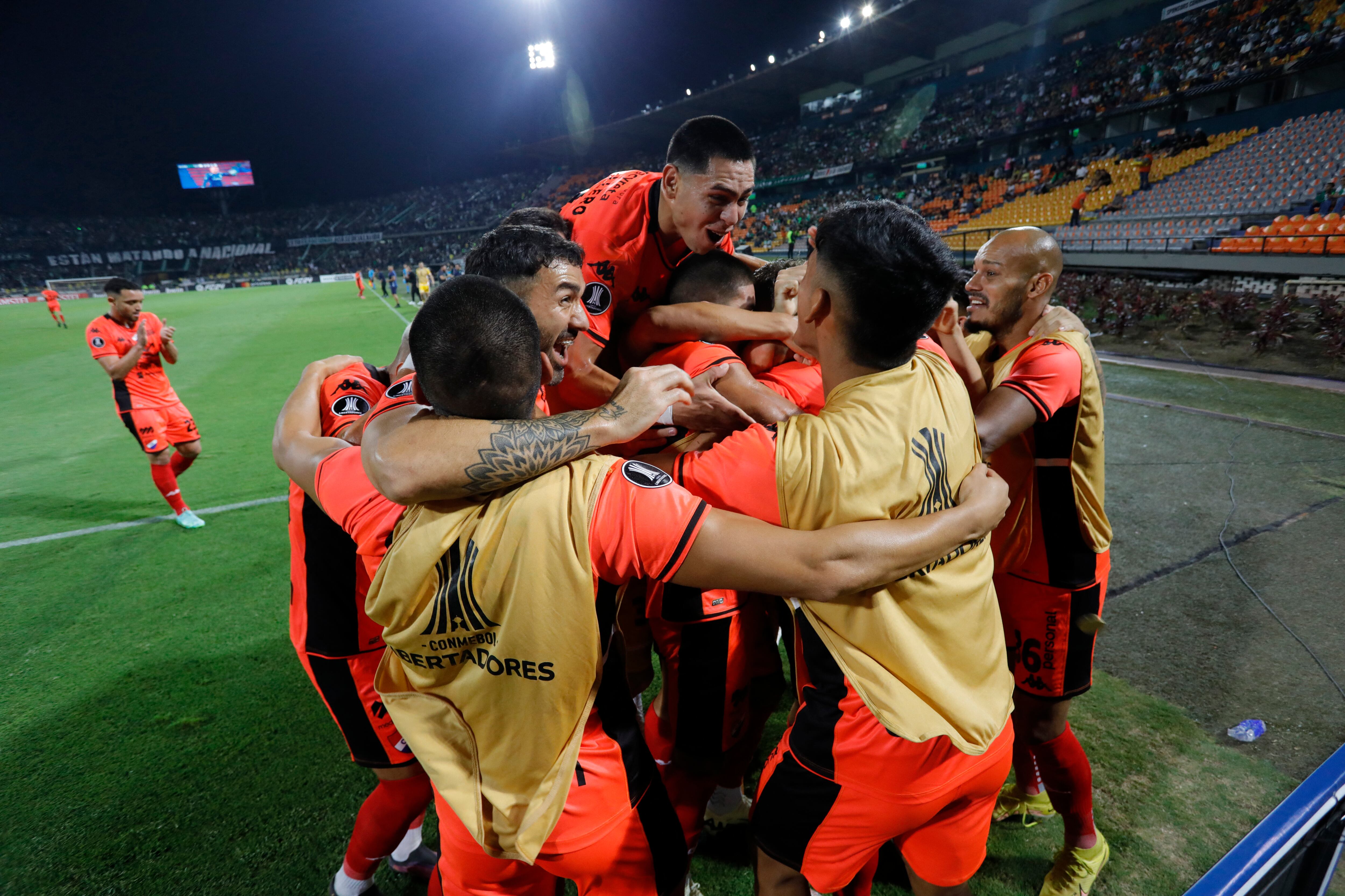 El delantero de Nacional Juan Alfaro (Cubierto) celebra con sus compañeros después de marcar un gol durante el partido de fútbol de segunda ronda de la Copa Libertadores entre el Atlético Nacional de Colombia y el Nacional de Paraguay en el estadio Atanasio Girardot de Medellín el 28 de febrero de 2024. (Foto de JAIME SALDARRIAGA /AFP)