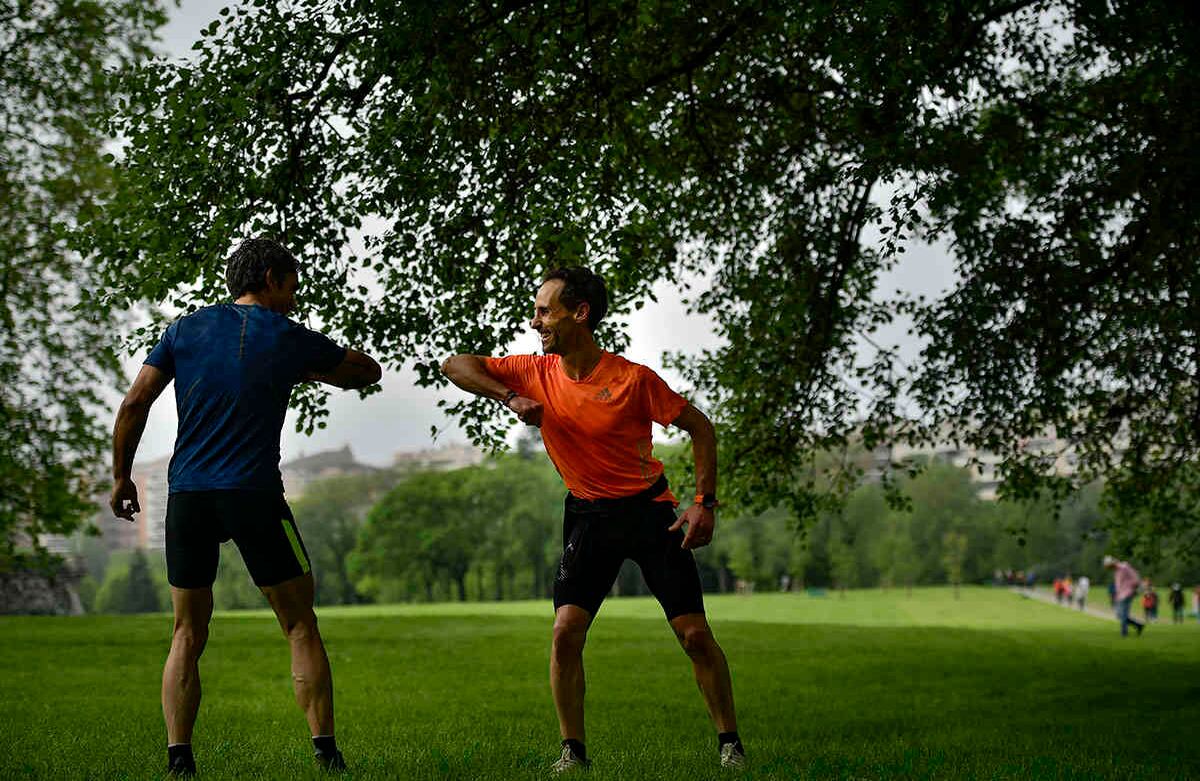 Dos hombres hacen un gesto con los codos, un saludo adoptado para no estrechar la mano y protegerse contra el coronavirus, en el parque Vuelta del Castillo, en Pamplona, norte de España. Este país relajó sus medidas de bloqueo el sábado, permitiendo a las personas de todas las edades para salir de sus casas a caminar o hacer ejercicio por primera vez desde el 14 de marzo. (Foto AP / Álvaro Barrientos)