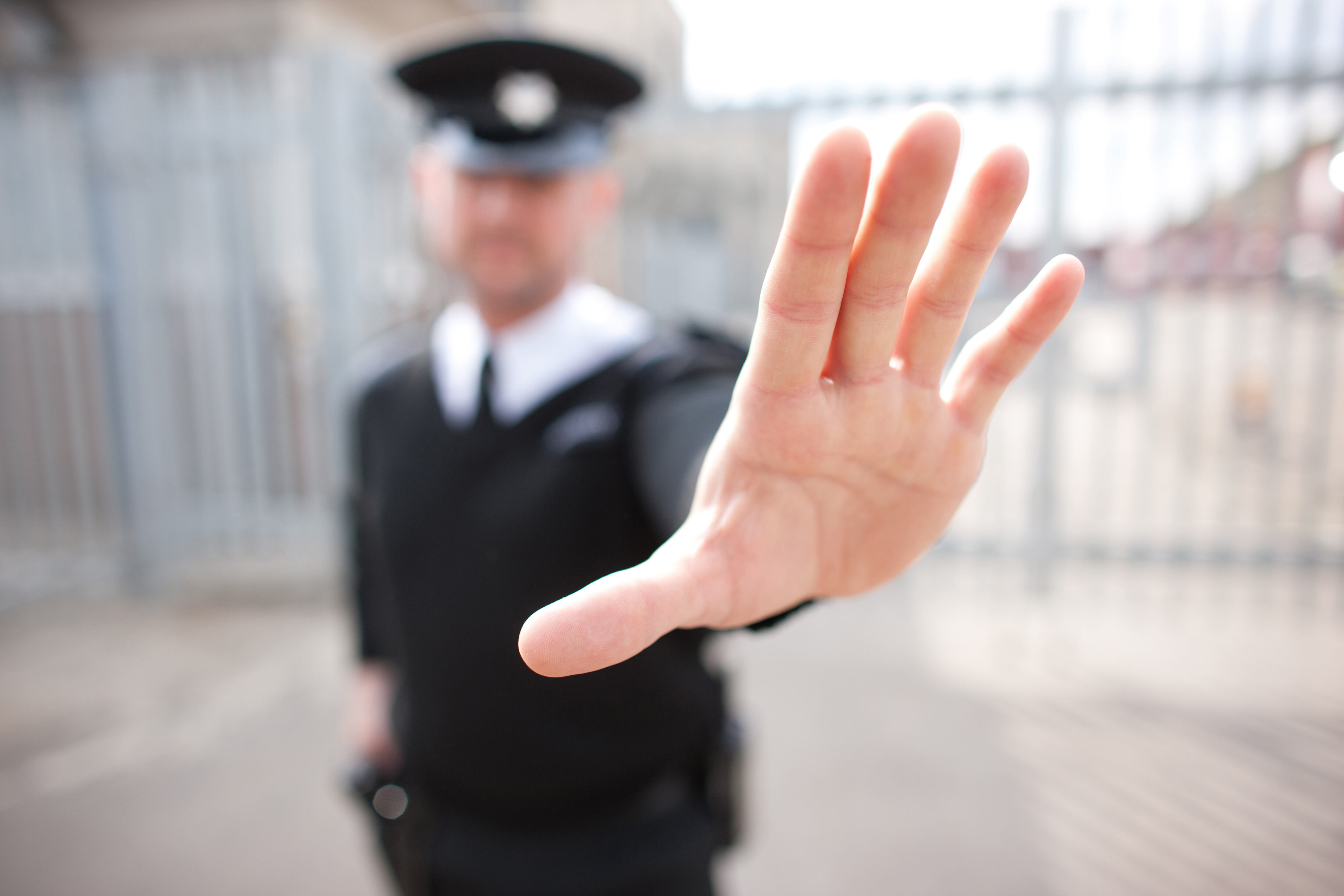 Guardia de seguridad en gesto de rechazo al paso de otra persona.