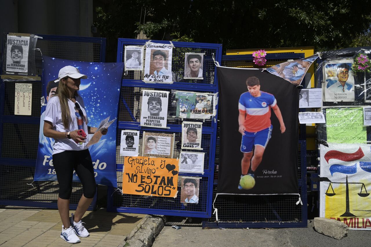 Una mujer junto a una cerca policial cubierta con imágenes en apoyo a Fernando Báez Sosa, quien fue asesinado por un grupo de rugbiers en 2020, afuera del tribunal luego de la audiencia de sentencia en Dolores, provincia de Buenos Aires, Argentina el 6 de febrero de 2023. (Photo by JUAN MABROMATA / AFP)
