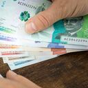 Man holds Colombian pesos in hand and counts on expenses or earnings calculator, Financial concept, home budget of Colombians