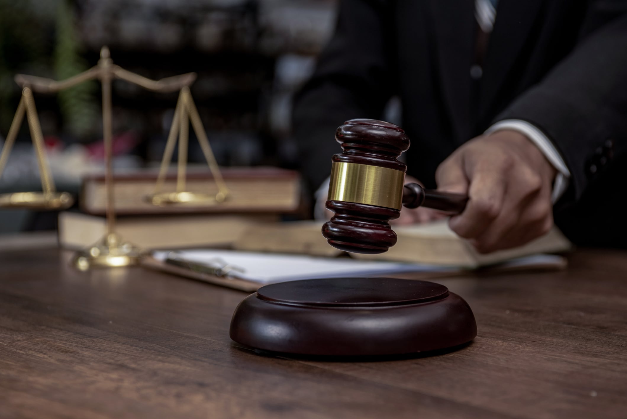 Man hand knocking a wooden judge gavel, law and auction concept.