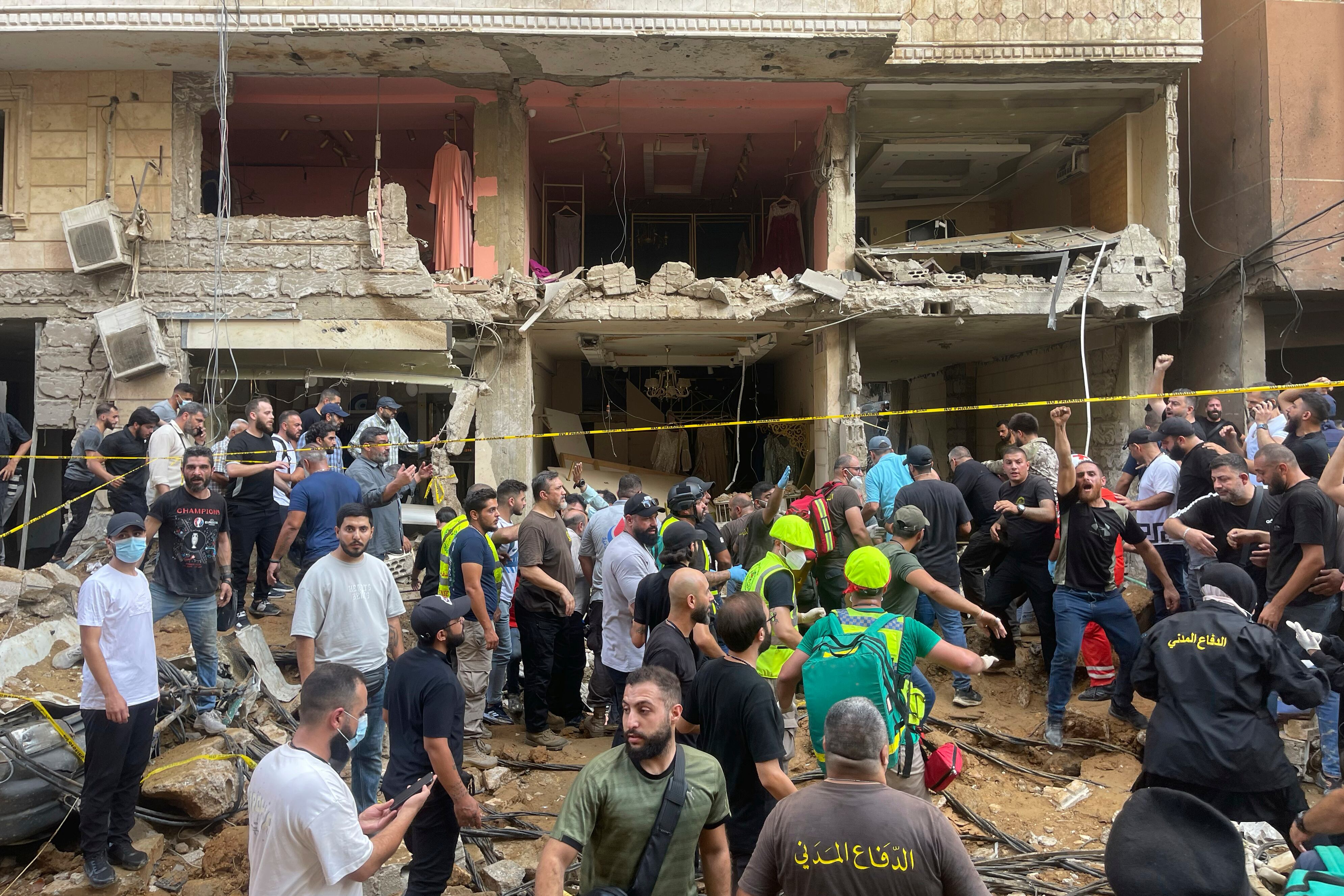 La gente se reúne cerca de un edificio dañado en el lugar de un ataque con misiles israelí en los suburbios del sur de Beirut, el viernes 20 de septiembre de 2024. (Foto AP/Bilal Hussein)