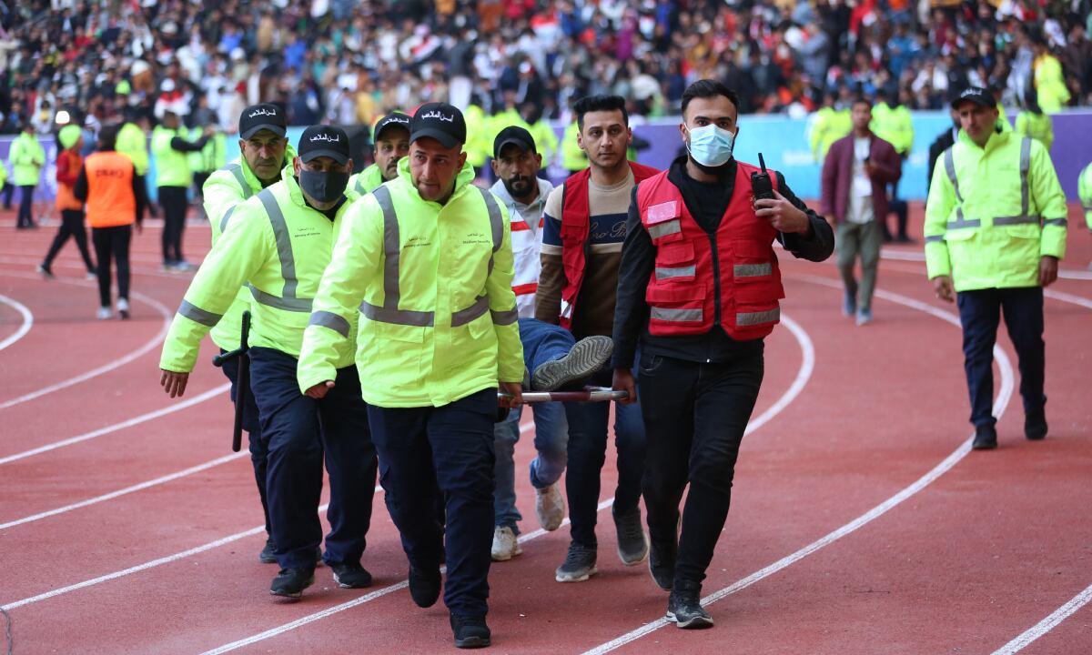 Iraqi stadium security team members carry an injured football fan into an emergency area at the Basra International Stadium following a stampede ahead of this evening's final match of the Arabian Gulf Cup between Iraq and Oman, on January 19, 2023 in Basra. One person was killed and dozens injured when a stampede broke out outside the football stadium in southern Iraq hours before the Gulf Cup final, medical and security sources said.
AFP/Hussein FALEH