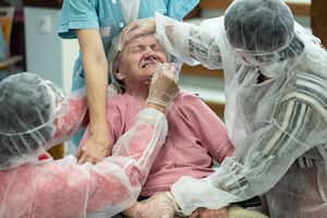 A woman is tested with a PCR COVID-19 test in a nursing home in Ammerschwihr, eastern France, Monday, Nov.9, 2020. The situation in hospitals and nursing homes is grim, with emergency wards approaching saturation and some sick patients being evacuated from struggling hospitals to others that still had space. With more than 1.8 million infections since the start of the health crisis, France has Europe's highest cumulative total of recorded cases and the fourth-highest worldwide. (AP Photo/Jean-Francois Badias)