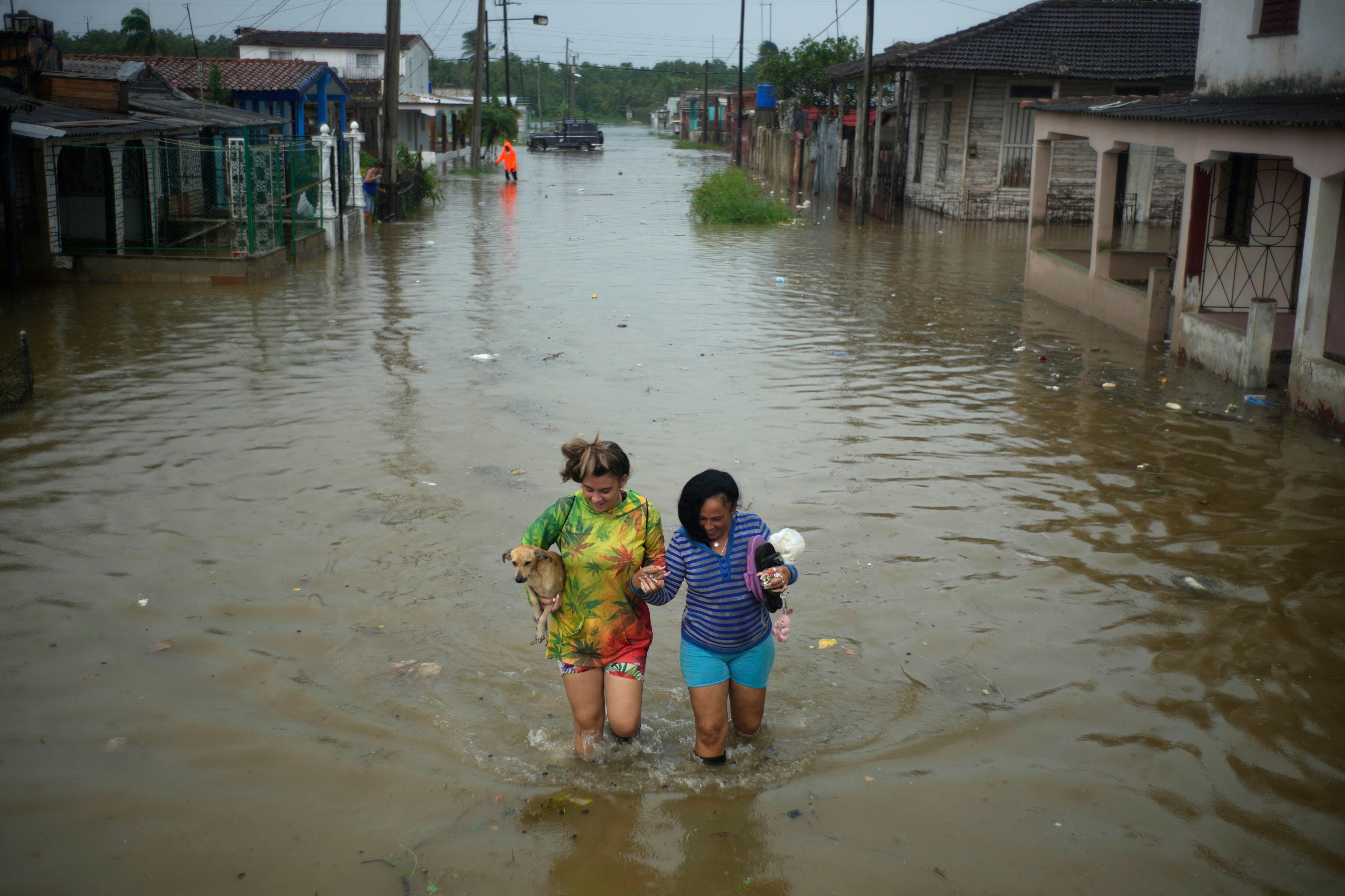 Los residentes caminan por una calle inundada por las lluvias provocadas por el huracán Idalia, en Batabano, Cuba, el martes 29 de agosto de 2023. Idalia se fortaleció hasta convertirse en huracán el martes y se dirigió hacia la costa del Golfo de Florida.