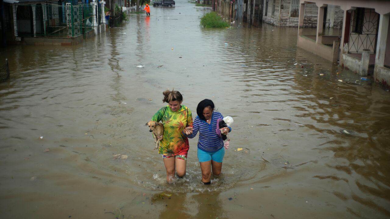 Los residentes caminan por una calle inundada por las lluvias provocadas por el huracán Idalia, en Batabano, Cuba, el martes 29 de agosto de 2023. Idalia se fortaleció hasta convertirse en huracán el martes y se dirigió hacia la costa del Golfo de Florida.