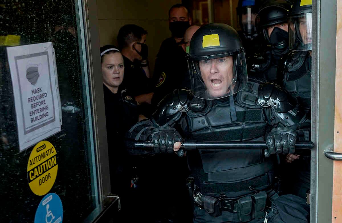 La Policía intenta proteger el edificio de seguridad pública de los manifestantes el lunes 24 de agosto de 2020, en Kenosha, Wisconsin. El gobernador de Wisconsin, Tony Evers, convocó a la Guardia Nacional para detener otra ronda de protestas violentas después de que la policía disparara contra un hombre negro bajo Las turbias circunstancias convirtieron a Kenosha en la ciudad más reciente del país en un verano de disturbios raciales. Foto: Morry Gash / AP 