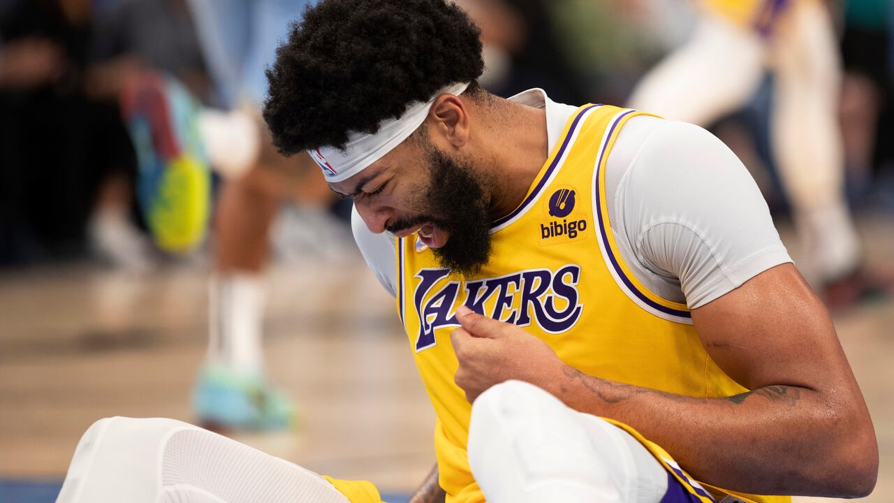 Los Angeles Lakers forward Anthony Davis winces as he holds his hand after a collision during the second half of the team's NBA basketball game against the Memphis Grizzlies on Thursday, Dec. 9, 2021, in Memphis, Tenn. (AP Photo/Nikki Boertman)