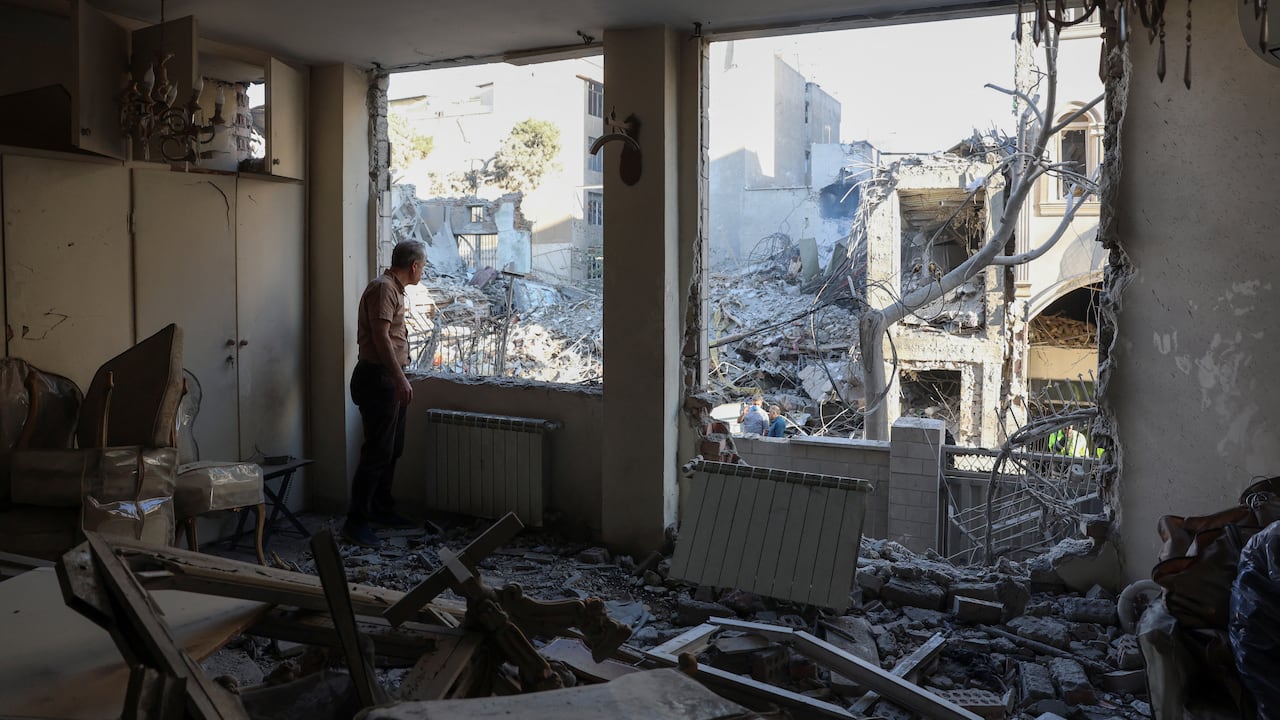 An Iranian resident looks out the window of his damaged home after Israeli-American strikes that according to local media reports destroyed the Rafi-Nia Synagogue and nearby residential buildings in Tehran, on April 7 2026. A synagogue in Tehran was �completely destroyed� during Israeli-American strikes early April 7, the Mehr news agency and the daily newspaper Shargh reported on the 39th day of the war against Israel and the United States. (Photo by AFP) /