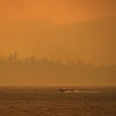 Un bote viaja a lo largo del lago Okanagan mientras el humo del incendio forestal McDougall Creek cubre el área, el viernes 18 de agosto de 2023, en Kelowna, Columbia Británica. (Darryl Dyck/The Canadian Press vía AP)