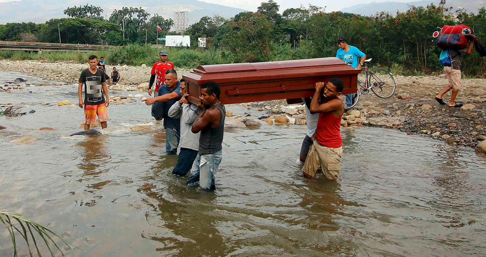 Familiares llevan los restos de Florentino Torrado a través del río Táchira a Colombia para su entierro, cerca del puente internacional Simón Bolívar, que las autoridades venezolanas solo abren a estudiantes y enfermos en Cúcuta, Colombia. FOTO: Schneyder Mendoza/AP