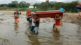 Familiares llevan los restos de Florentino Torrado a través del río Táchira a Colombia para su entierro, cerca del puente internacional Simón Bolívar, que las autoridades venezolanas solo abren a estudiantes y enfermos en Cúcuta, Colombia. FOTO: Schneyder Mendoza/AP