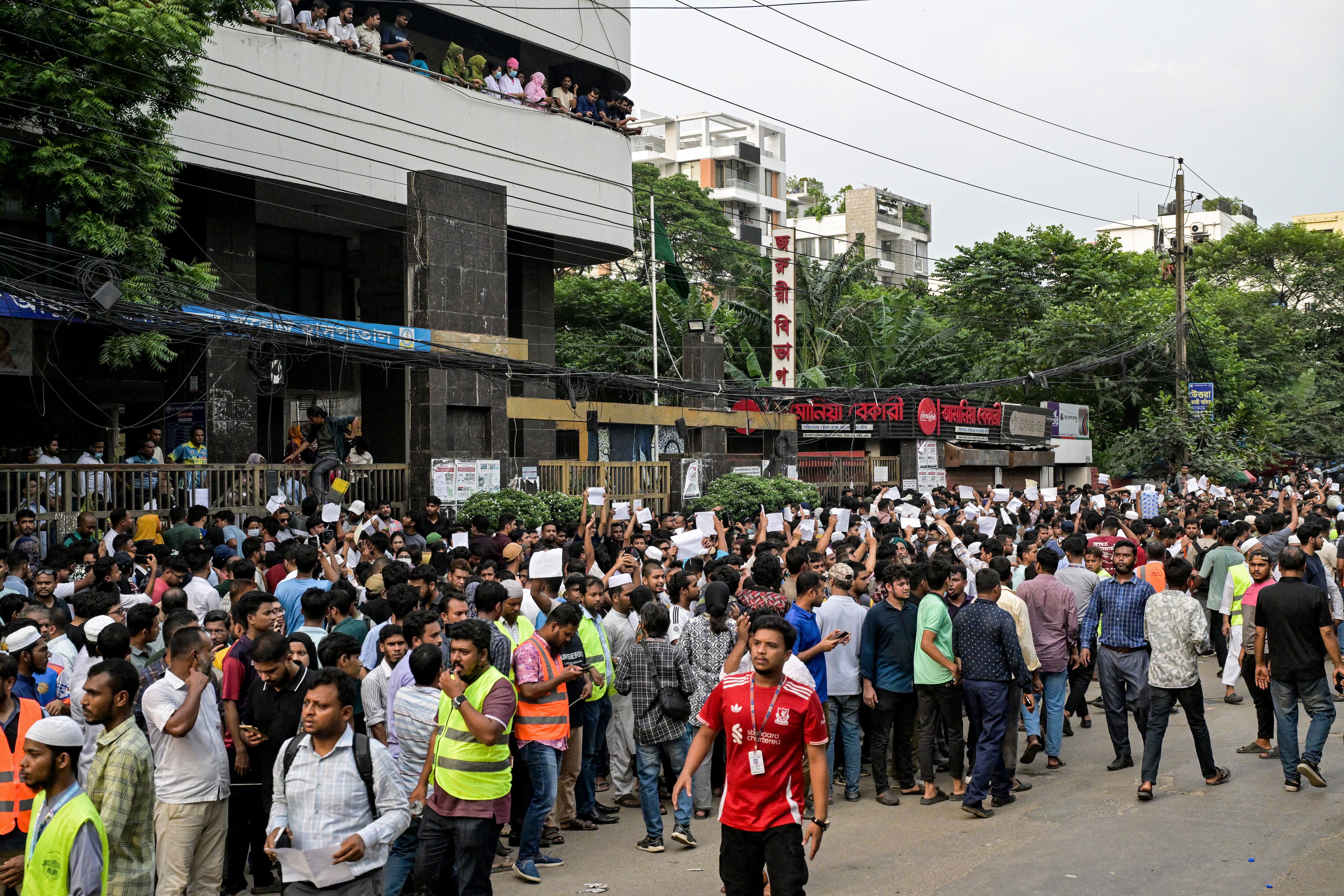 Donantes de sangre se reúnen frente a un hospital con documentos tras el accidente de un avión de entrenamiento de la Fuerza Aérea contra una escuela en Daca.