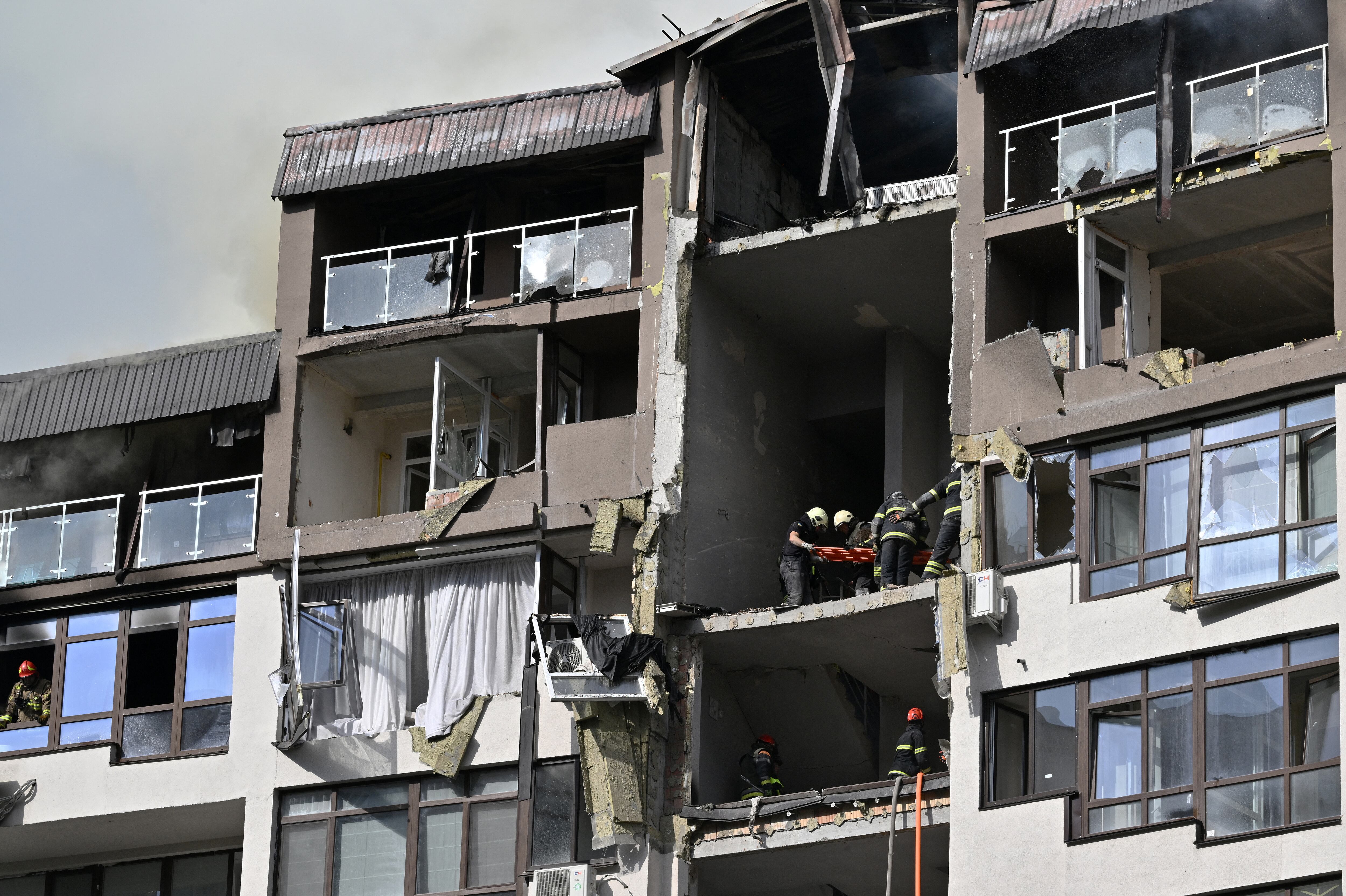 Los rescatistas evacuan a una persona de un edificio residencial dañado alcanzado por misiles rusos en Kyiv el 26 de junio de 2022, en medio de la invasión rusa de Ucrania. - “La cumbre del G7 debe responder con más sanciones contra Rusia y más armas pesadas para Ucrania”, instó el 26 de junio de 2022 Dmytro Kouleba, jefe de la diplomacia ucraniana, en Twitter, llamando a “derrotar al imperialismo ruso enfermo”. (Foto de Genya SAVILOV / AFP)