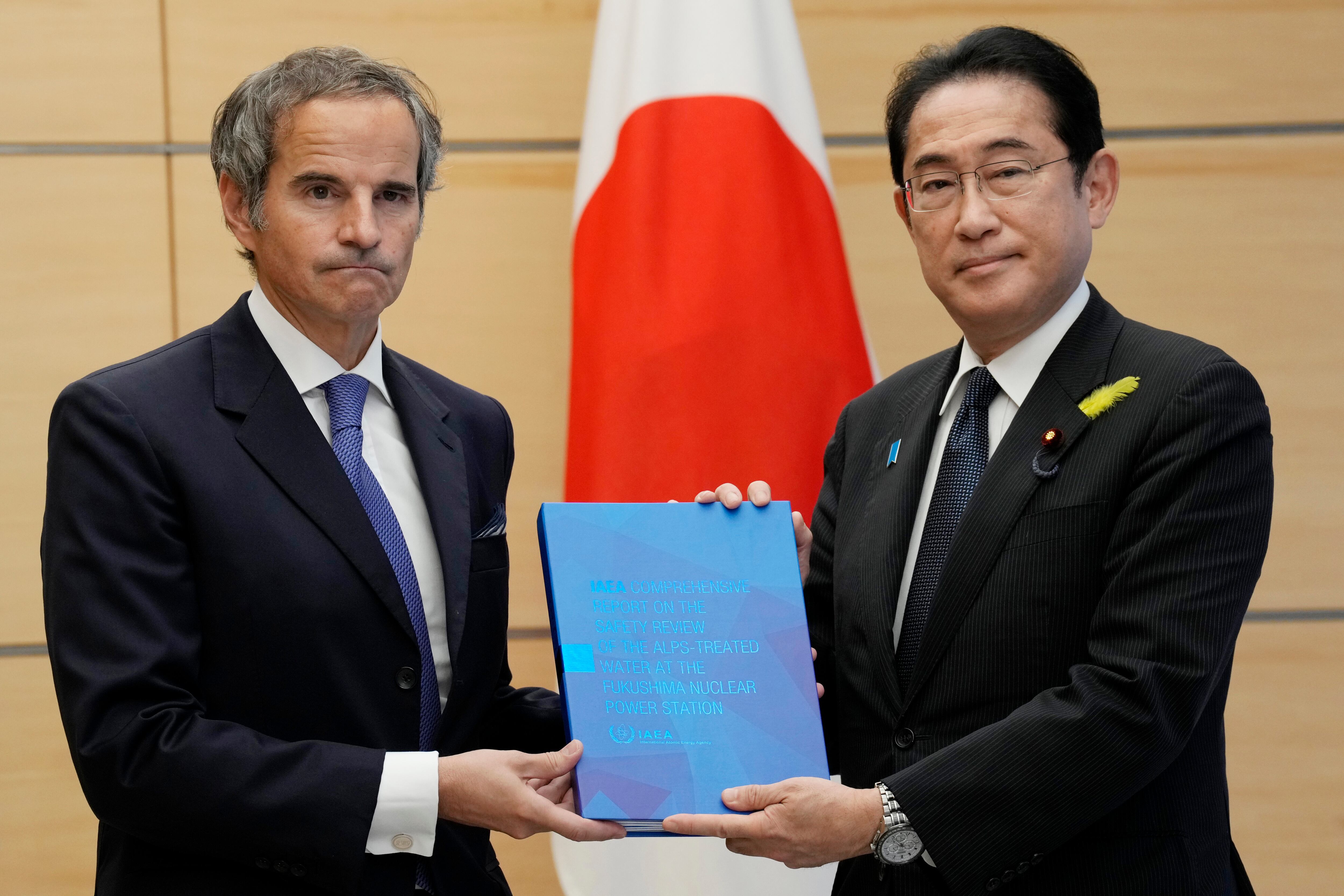 Rafael Mariano Grossi, director general de la Agencia Internacional de Energía Atómica, a la izquierda, presenta el informe completo del OIEA sobre la liberación de agua tratada de Fukushima al primer ministro japonés Fumio Kishida, a la derecha, en la oficina del primer ministro el martes 4 de julio de 2023 en Tokio.