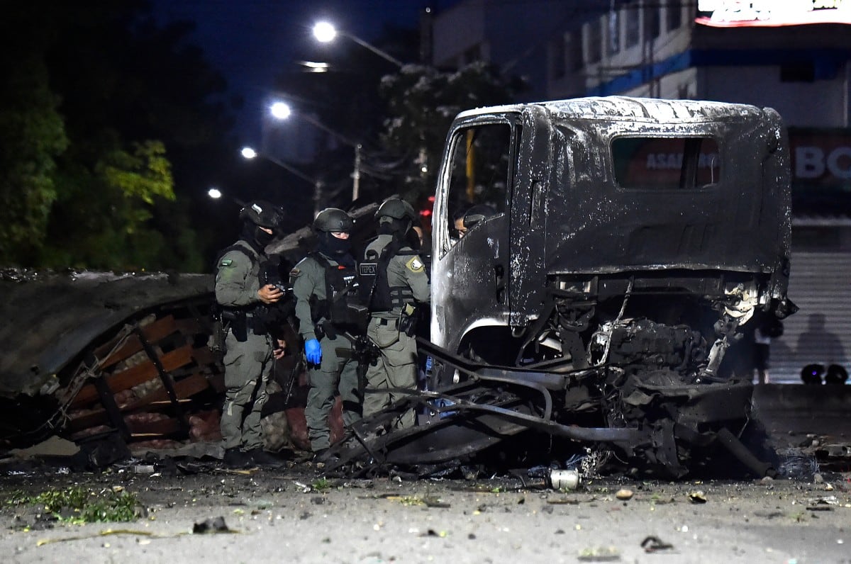 Policías inspeccionan los restos de un camión tras la explosión de un carro bomba en Cúcuta.