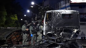 Policías inspeccionan los restos de un camión tras la explosión de un carro bomba en Cúcuta.