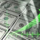 Gráfico económico: flecha verde ascendente y billetes de un dólar.