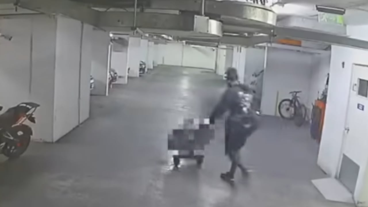 En la imagen, Abel Stiven Carabalí sacando de un apartamento en una maleta, el cuerpo sin vida de su amigo.