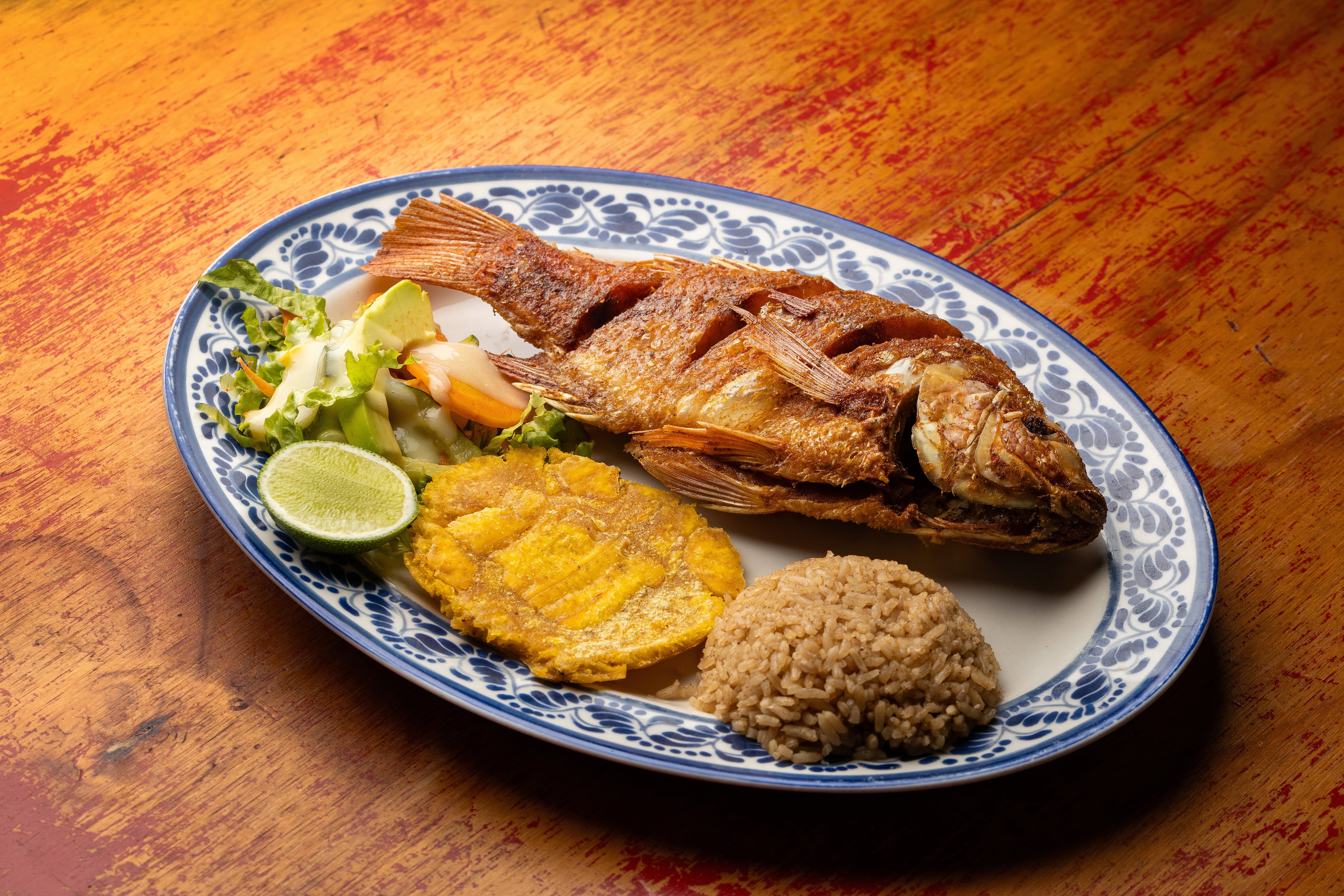 Pescado frito acompañado de arroz con coco, plato típico de la región.
