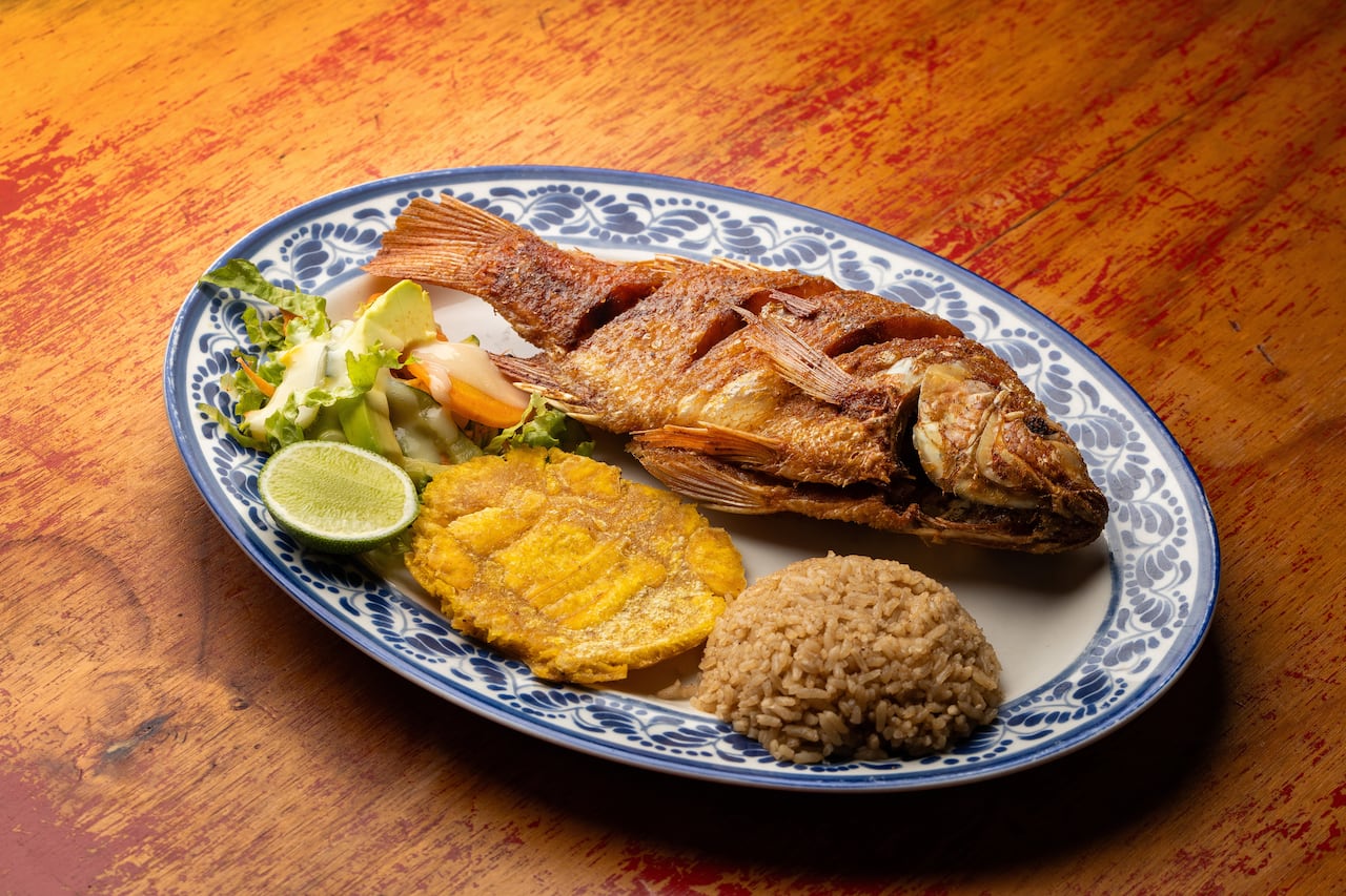 Pescado frito acompañado de arroz con coco, plato típico de la región.