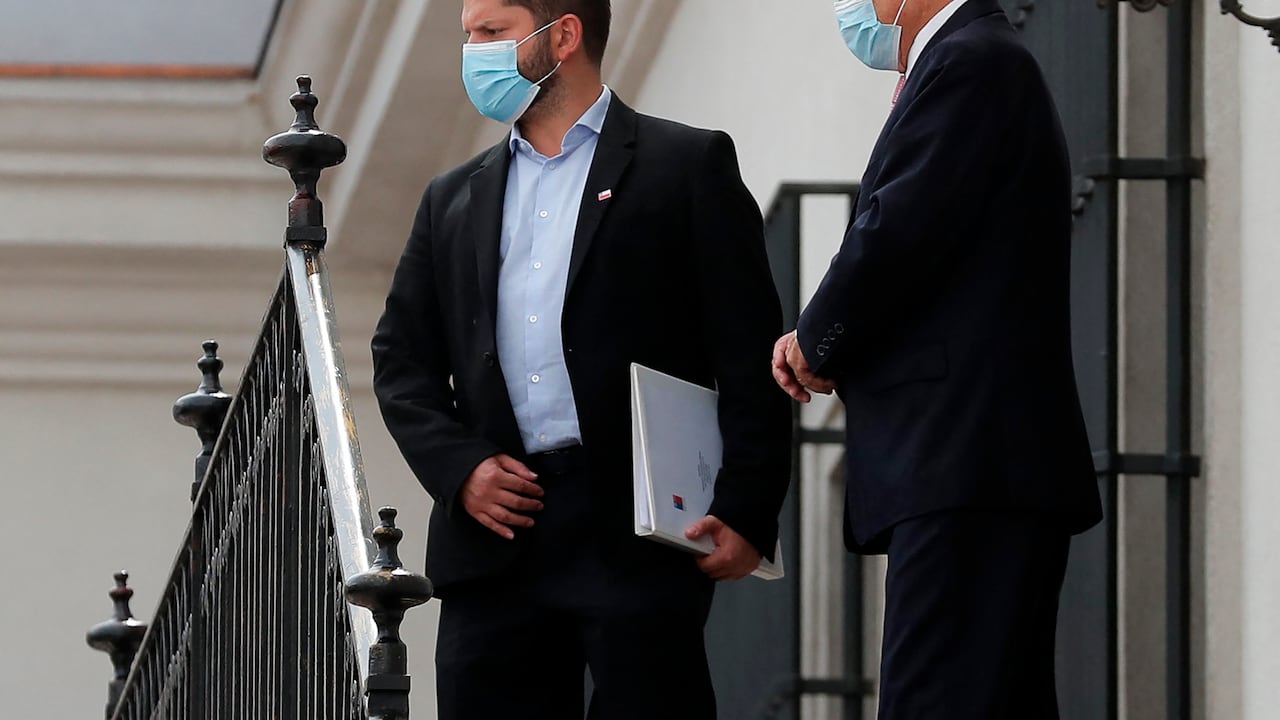 El presidente electo de Chile, Gabriel Boric (izq.), y el presidente Sebastián Piñera, conversan después de mantener una reunión en el Palacio Presidencial de La Moneda en Santiago. (Photo by Javier TORRES / AFP)
