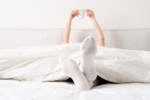 Mantener los pies calientes con medias puede prevenir la incomodidad causada por el frío durante la noche.