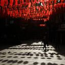 Una mujer que usa una mascarilla para frenar la propagación del coronavirus camina debajo de linternas colgadas al otro lado de la calle para celebrar el Año Nuevo Lunar chino, que marca el Año del Buey, en el distrito de Chinatown del centro de Londres, el viernes 12 de febrero de 2021. Las celebraciones del Año Nuevo chino se silenciaron en Londres, ya que Inglaterra permanece en su tercer bloqueo nacional desde que comenzó el brote de coronavirus. Foto: AP / Matt Dunham.