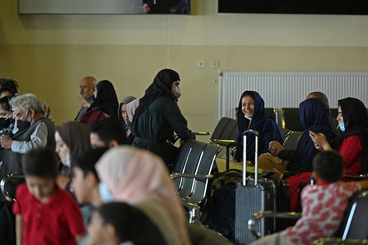 Los pasajeros se sientan en un salón mientras esperan abordar un vuelo de Pakistan International Airlines (PIA), el primer vuelo comercial internacional desde que los talibanes recuperaron el poder el mes pasado, en el aeropuerto de Kabul el 13 de septiembre de 2021 (Foto de Aamir QURESHI / AFP).