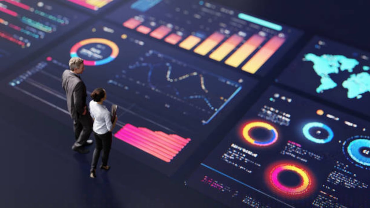 Personas reunidas frente a una mesa con gráficos, post-its y diagramas mientras diseñan una estrategia de marketing.