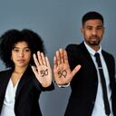 Shot of businessman and businesswoman advocating for gender equality against a grey studio background