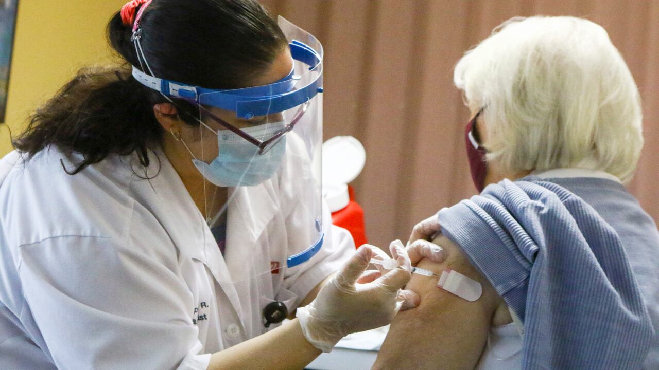 ARCHIVO - En esta fotografía de archivo un farmacéutico le da a una mujer una vacuna Moderna COVID-19 en un complejo de apartamentos en Merrillville, Indiana. (Kale Wilk / The Times vía AP, archivo)