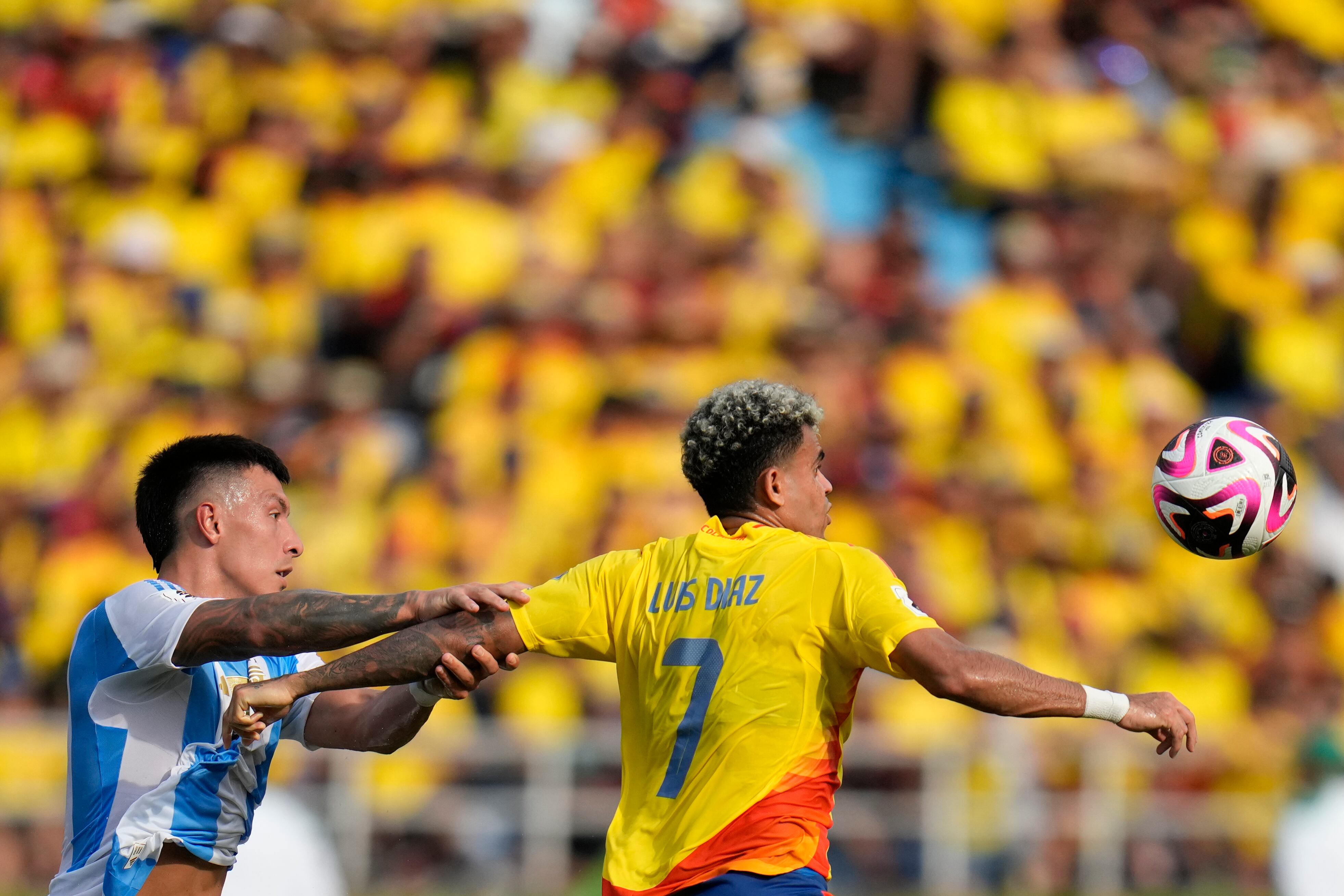 Colombia's Luis Diaz, right, and Argentina's Lisandro Martinez battle for the ball during a qualifying soccer match for the FIFA World Cup 2026 at the Metropolitano Roberto Melendez stadium in Barranquilla, Colombia, Tuesday, Sept. 10, 2024. (AP Photo/Fernando Vergara)