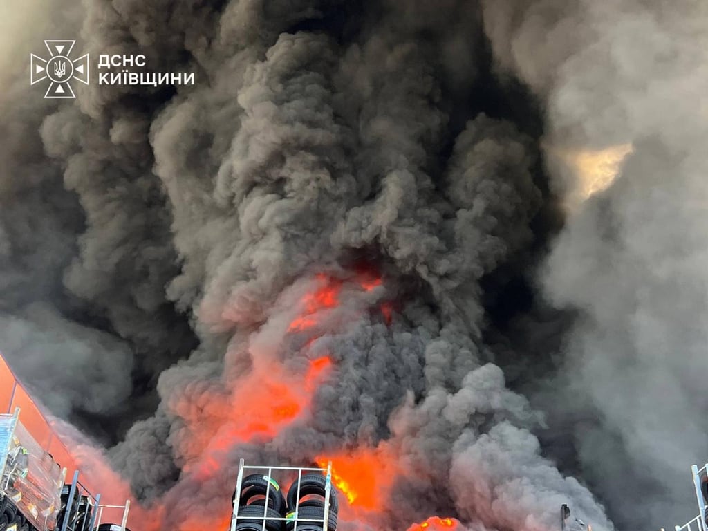 En esta imagen, proporcionada por el Servicio de Emergencias de Ucrania, los bomberos intentan sofocar un incendio en un almacén tras un ataque con drones rusos cerca de Kiev, Ucrania.