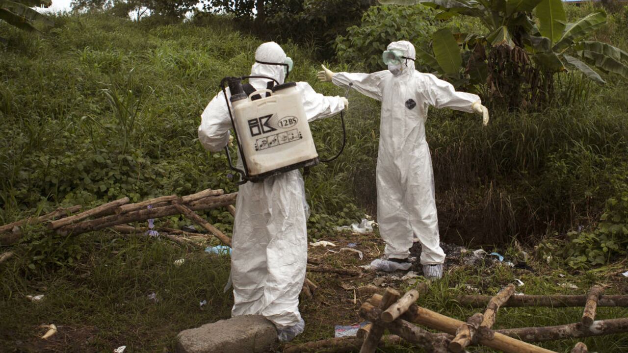 Trabajadores de la salud se aplican desinfectante mútuamente luego de trabajar en una morgue con personas de quienes se sospecha murieron por ébola, Kenema, Sierra Leona, 24 de septiembre, 2014.