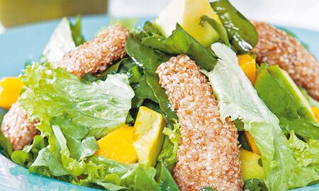 Ensalada con pollo apanado en ajonjolí acompañado con vinagreta de curry y hierbabuena.