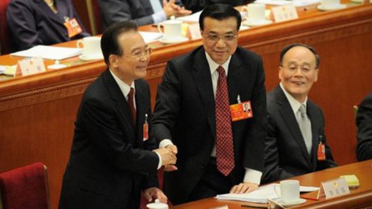 Wen Jiabao (izq.) da la mano a su futuro sucesor como primer ministro, Li Keqiang, durante la apertura de la sesión parlamentaria, este martes en Pekín.