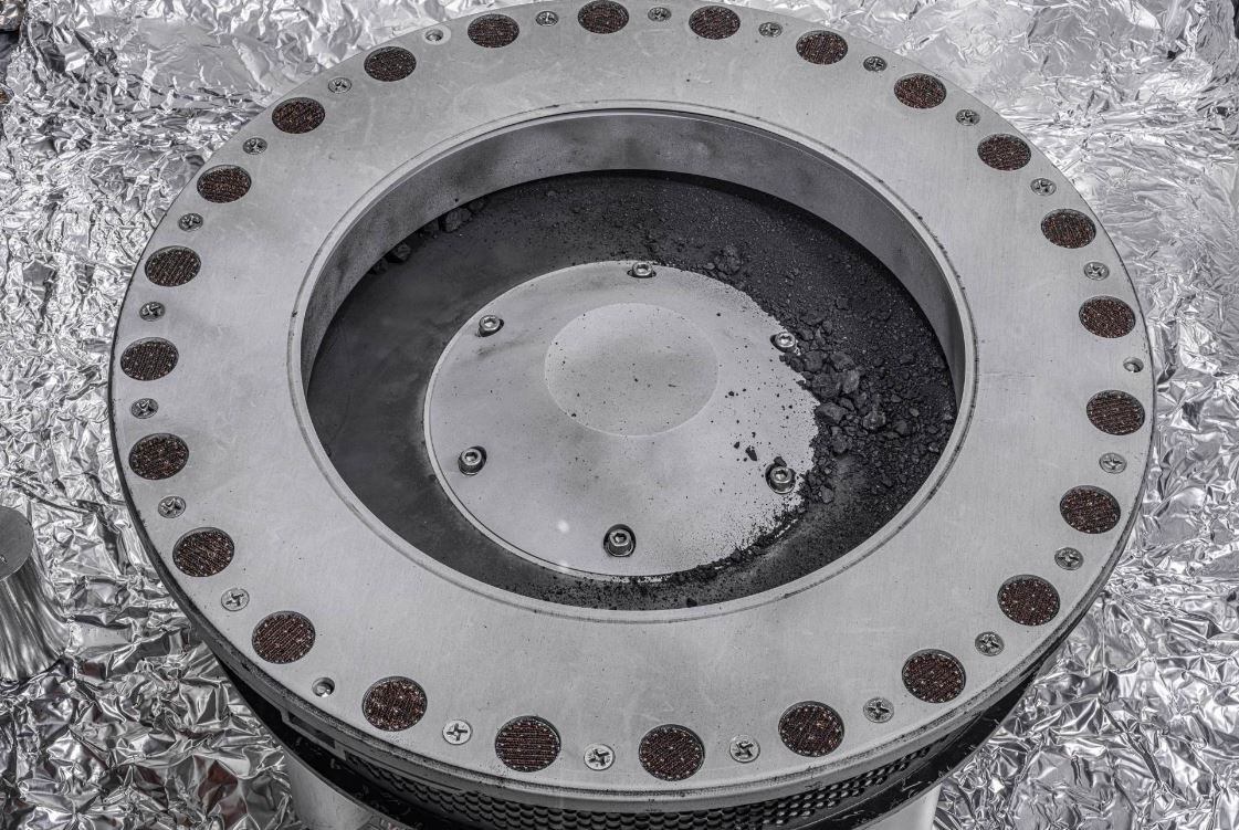 Una vista del exterior del recolector de muestras OSIRIS-REx. En el centro a la derecha se puede ver material de muestra del asteroide Bennu.