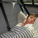 Joven durmiendo en su carro.