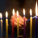 A person lighting Hanukkah Candles in a menorah. People celebrate Chanukah by lighting candles on a menorah, also called a Hanukiyah. Each night, one more candle is lit.