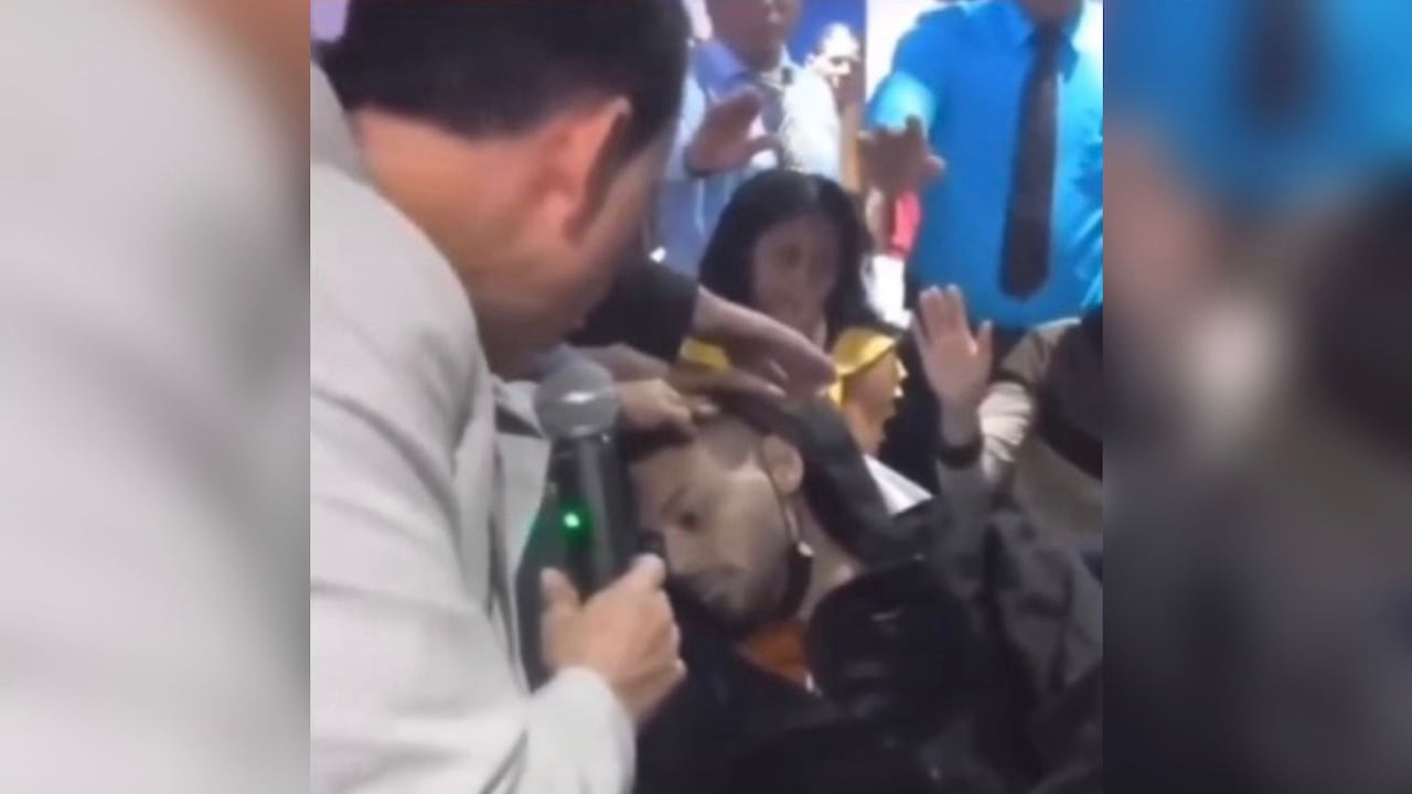 El pastor Esteban Acosta orando por una persona que habría resucitado.