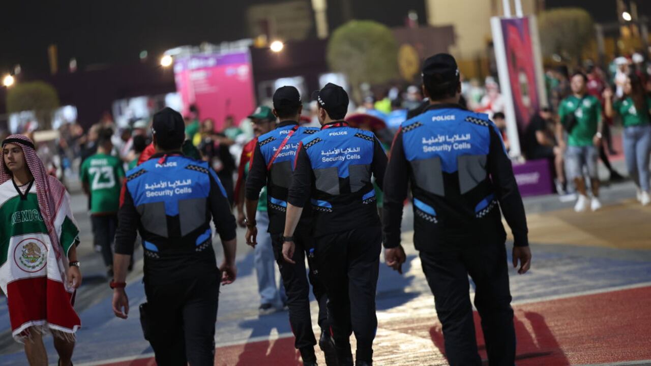 22 November 2022, Qatar, Doha: Soccer: World Cup, Mexico - Poland, preliminary round, Group C, Matchday 1, Stadium 974, Security staff pass a fan of Mexico outside the stadium. Photo: Christian Charisius/dpa (Photo by Christian Charisius/picture alliance via Getty Images)