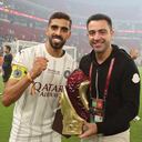Sadd's coach Xavi (R) and Sadd's midfielder Hassan al-Haydos celebrate with the trophy after winning the Amir Cup final football match between Al-Sadd and Al-Rayyan at the Al-Thumama Stadium in the capital Doha on October 22, 2021. (Photo by KARIM JAAFAR / AFP)