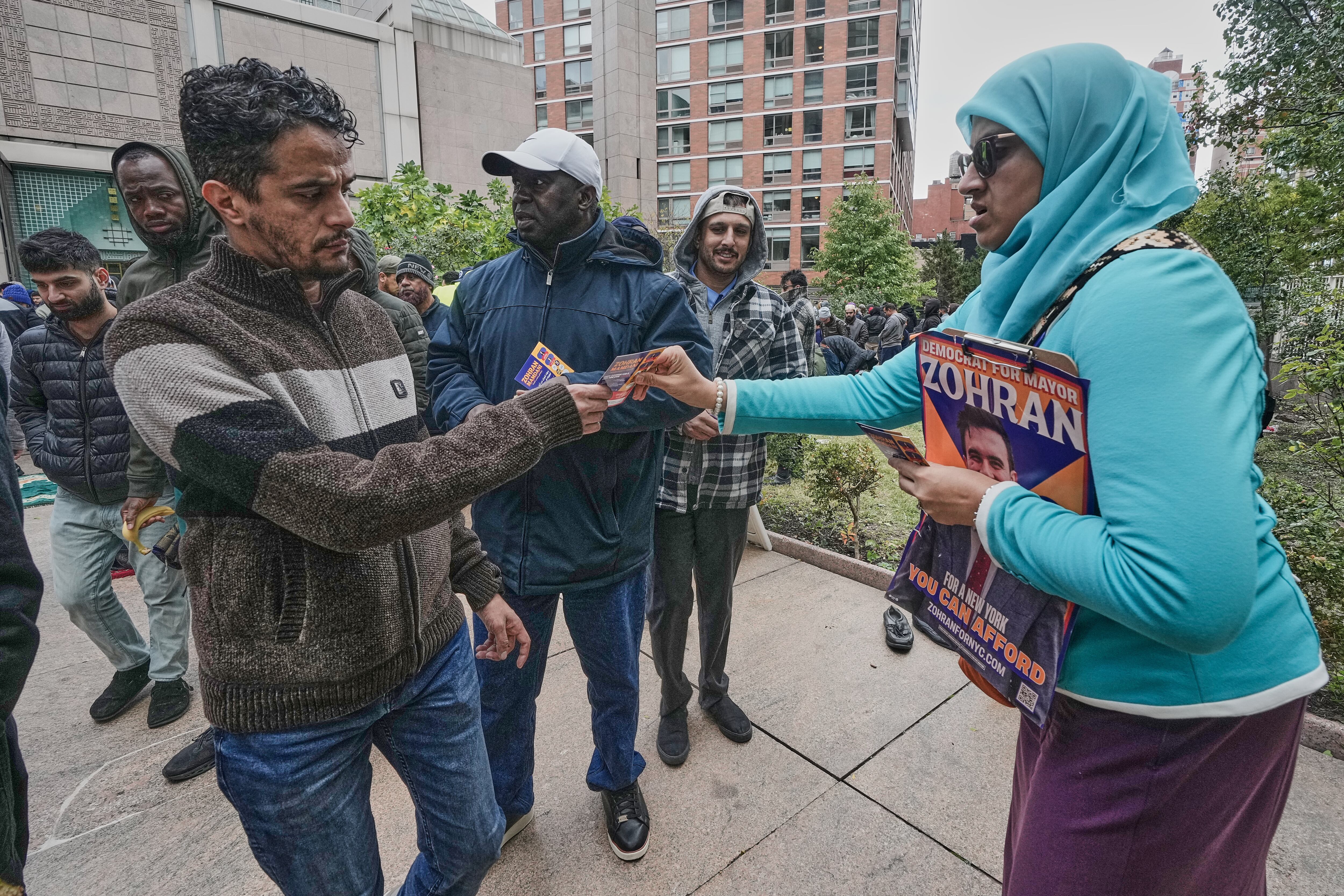 Zuleqa Husain, right, canvasser for New York mayoral candidate Zohran Mamdani, distributes campaign material at The Islamic Cultural Center of New York, Friday, Oct. 31, 2025. (AP Photo/Richard Drew)