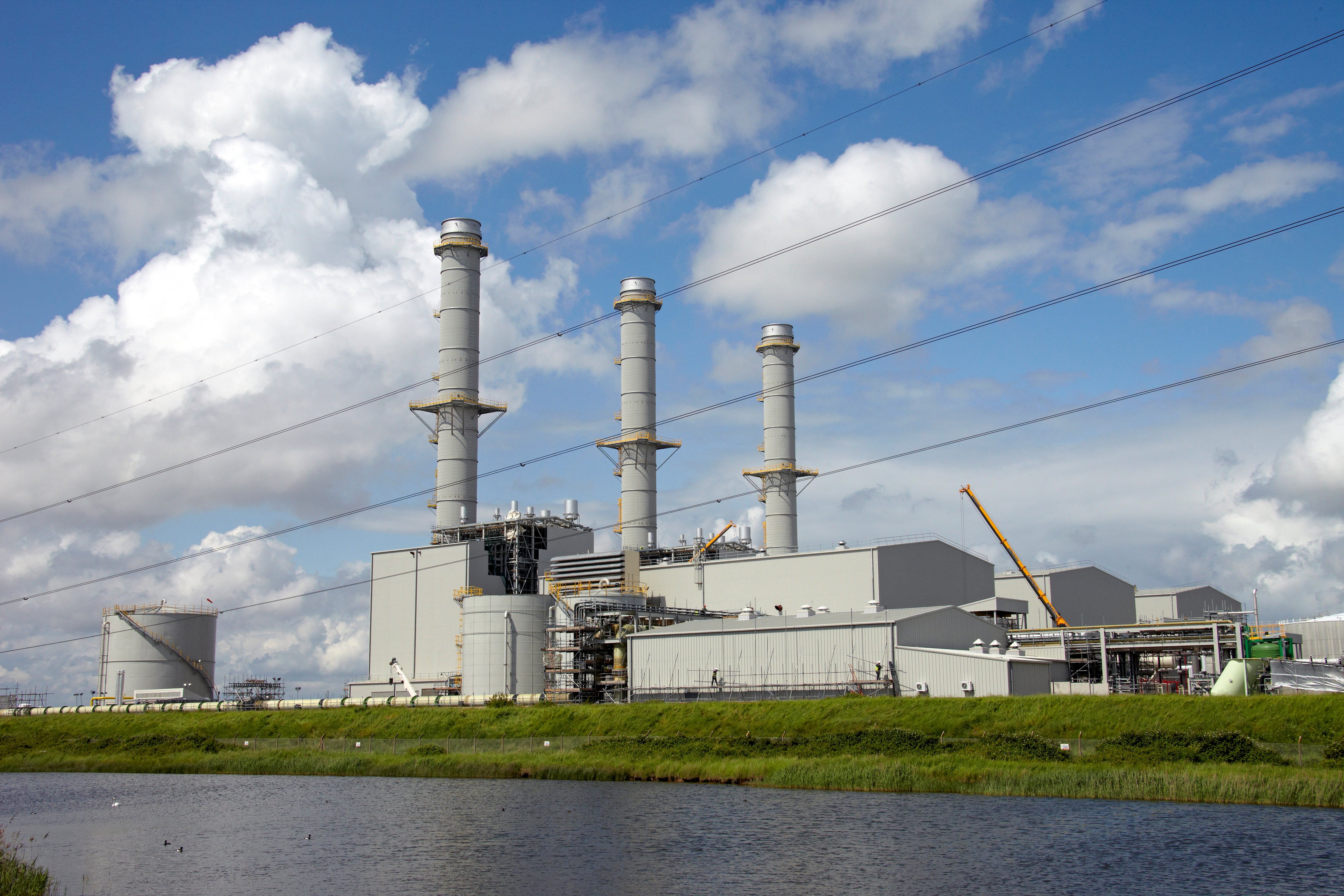 Gas-fired power station with chimneys and electricity transmission cables, Kent, England